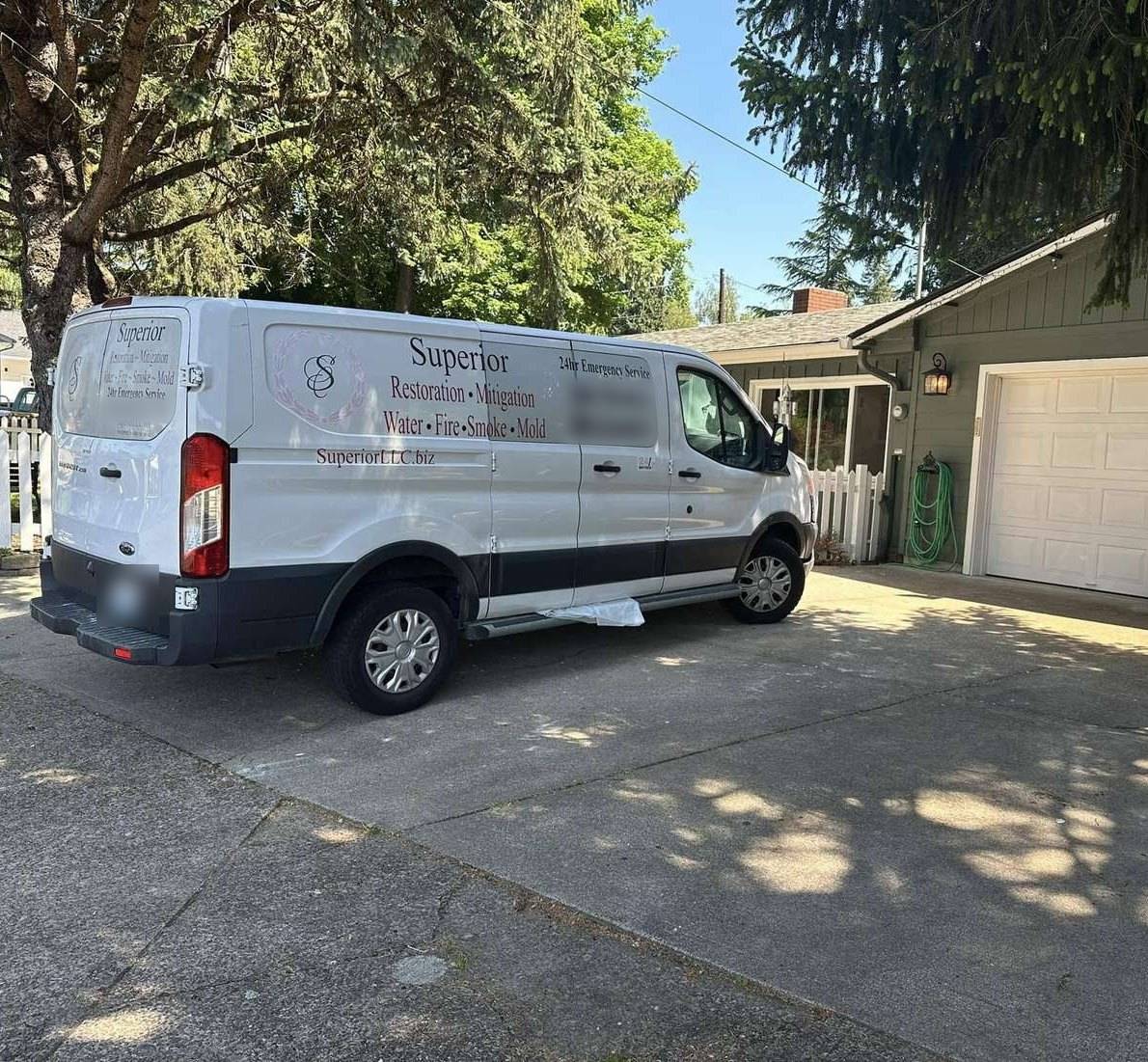 Superior Water & Fire Restoration’s branded service van parked in a driveway